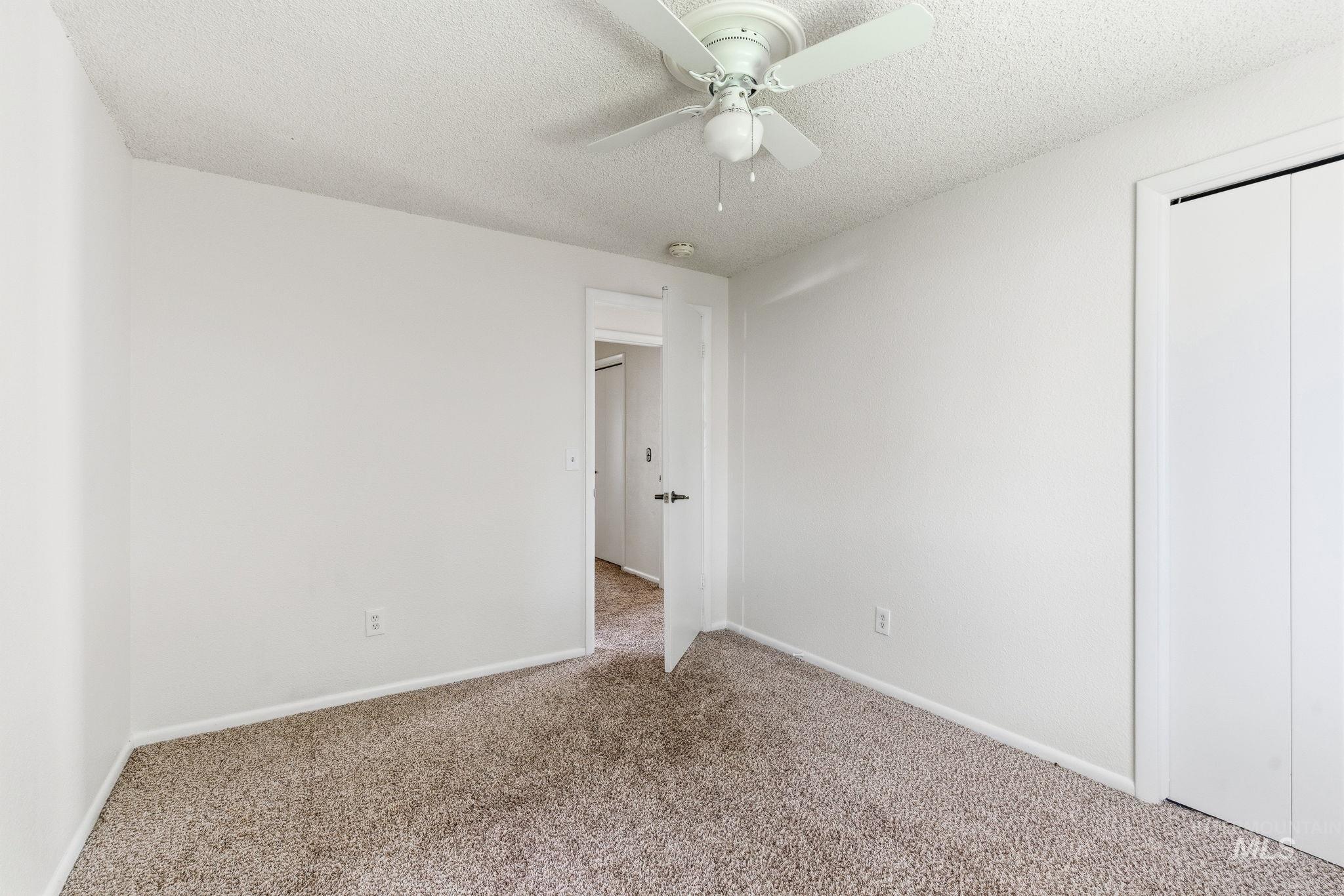 3911 South Constitution Way Boise, ID 83706 - Photo 25 of 40 Unfurnished bedroom featuring carpet floors, a textured ceiling, a ceiling fan, and a closet