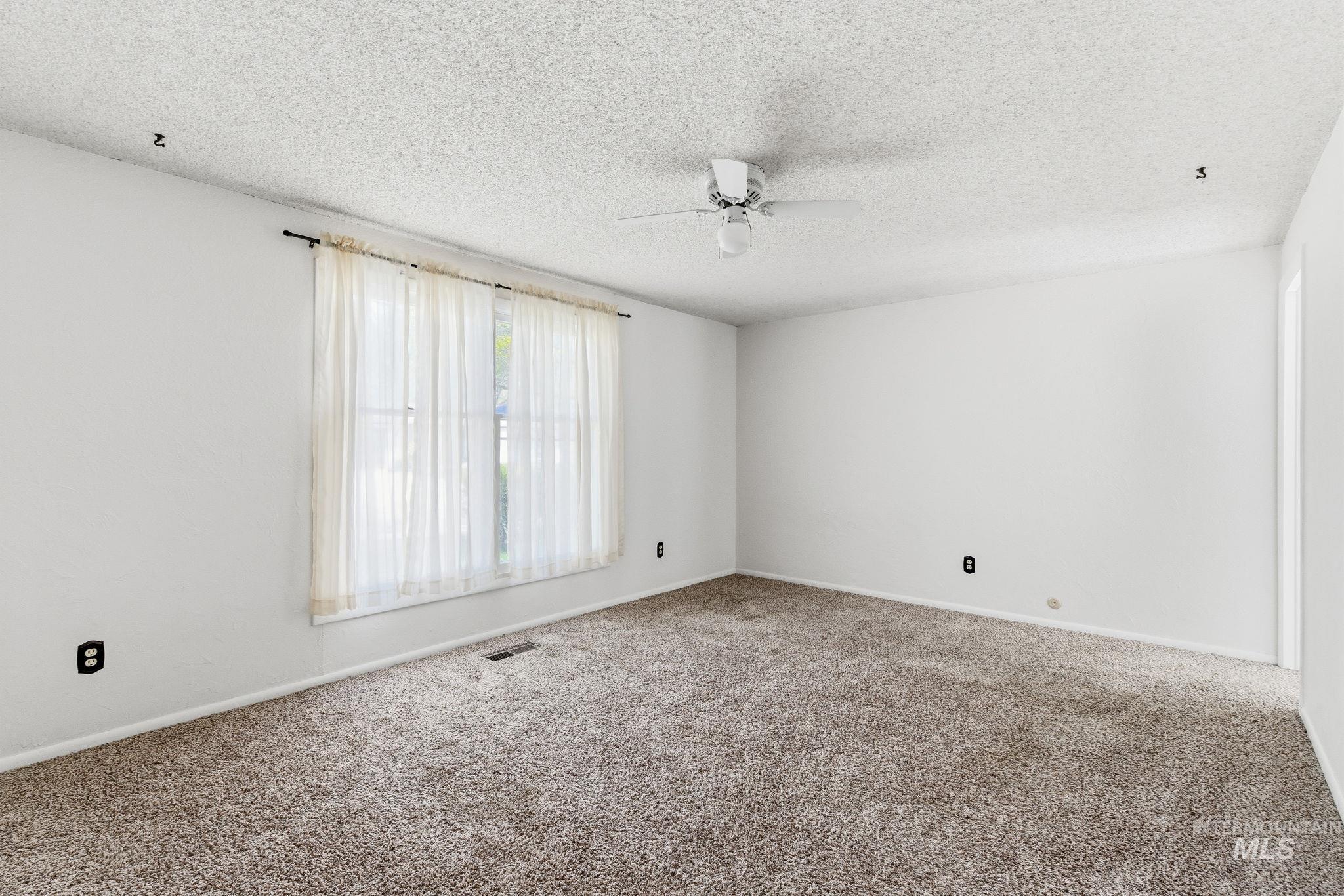 3911 South Constitution Way Boise, ID 83706 - Photo 26 of 40 Carpeted spare room featuring ceiling fan and a textured ceiling