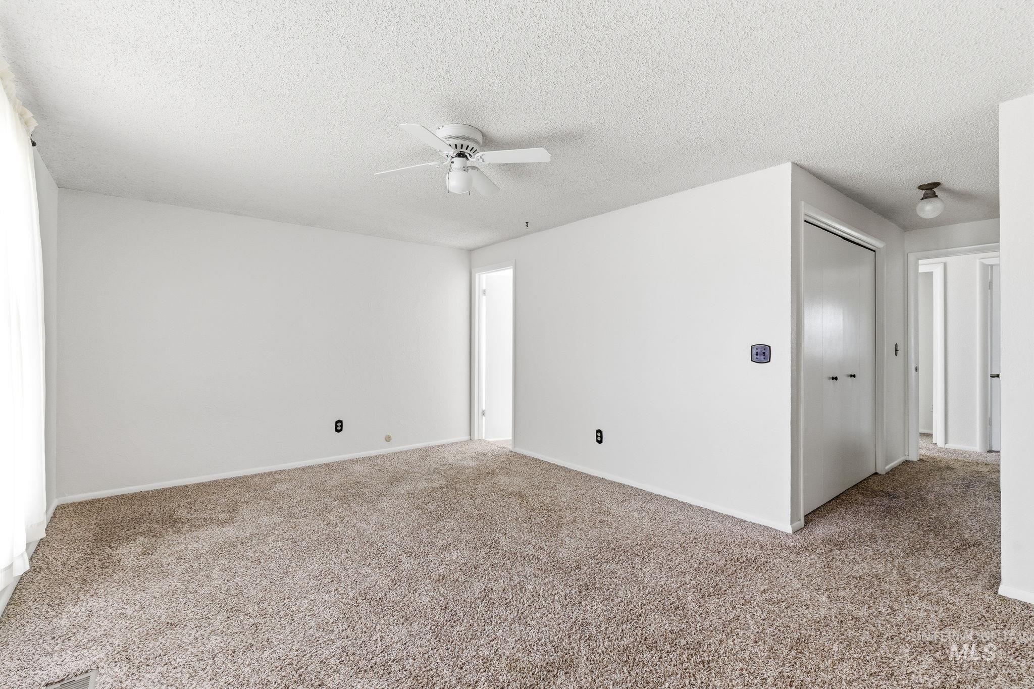 3911 South Constitution Way Boise, ID 83706 - Photo 27 of 40 Unfurnished room featuring carpet, a ceiling fan, and a textured ceiling