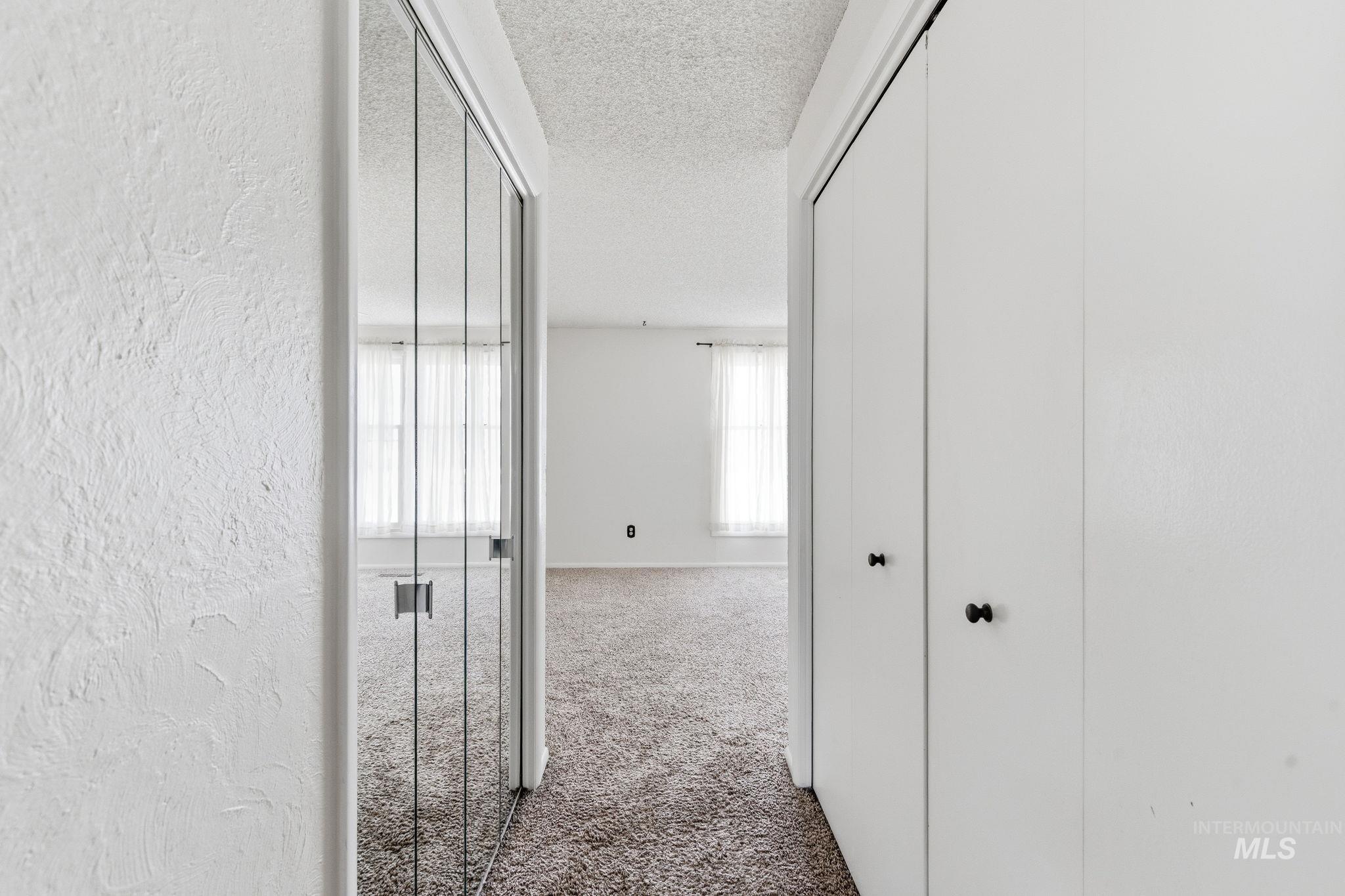 3911 South Constitution Way Boise, ID 83706 - Photo 28 of 40 Corridor with a textured ceiling, light carpet, and a textured wall