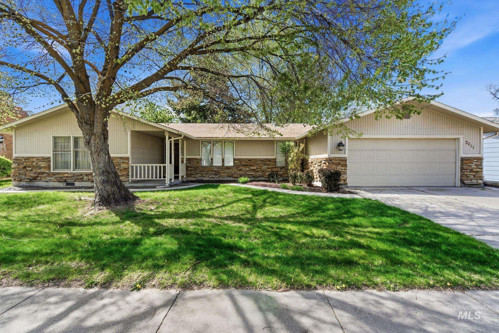 3911 South Constitution Way Boise, ID 83706 - Photo 3 of 40 Ranch-style home with stone siding, a garage, a front yard, and driveway