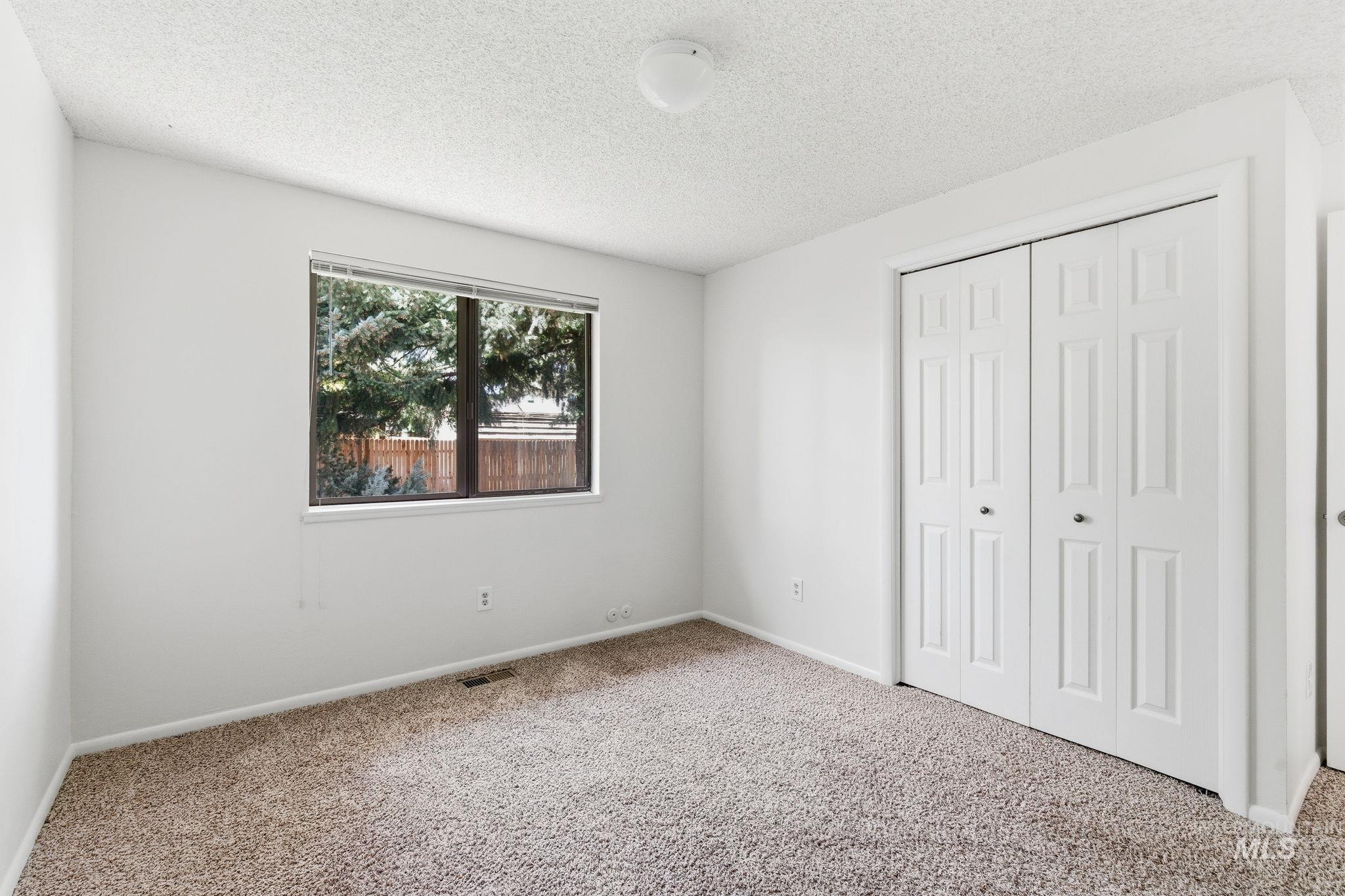 3911 South Constitution Way Boise, ID 83706 - Photo 33 of 40 Unfurnished bedroom featuring carpet, a closet, and a textured ceiling