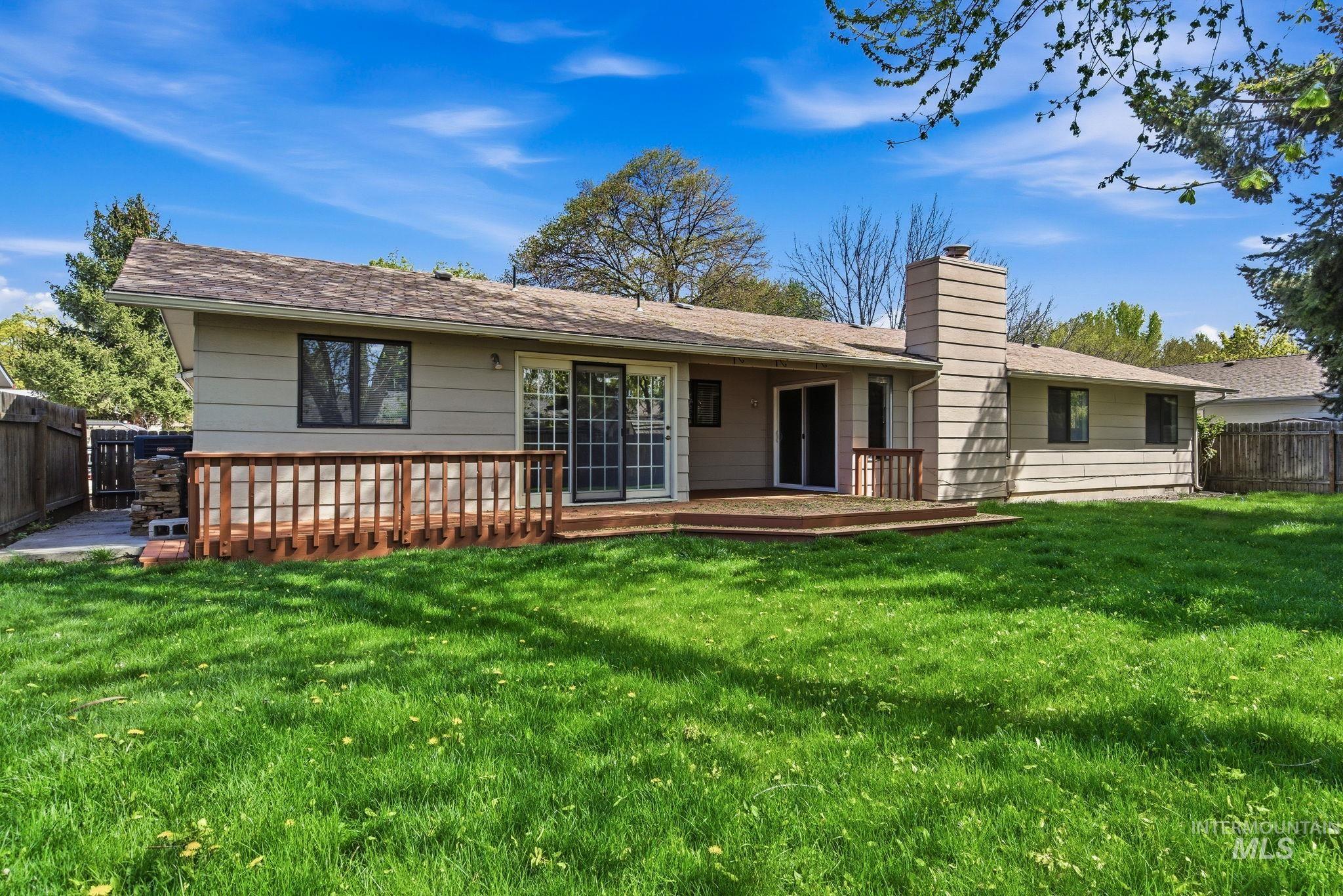 3911 South Constitution Way Boise, ID 83706 - Photo 37 of 40 Back of house with a fenced backyard, a deck, and a chimney