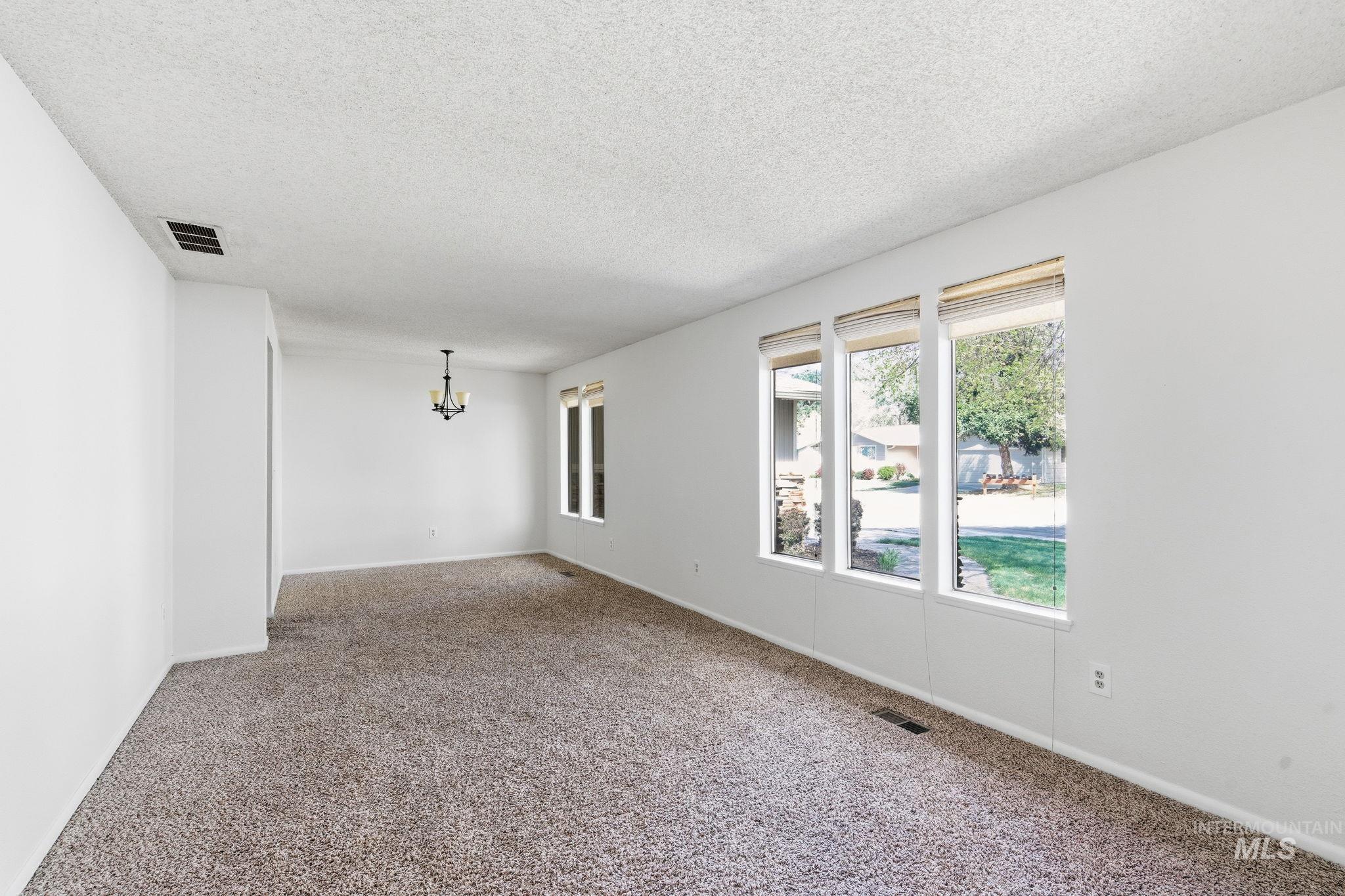 3911 South Constitution Way Boise, ID 83706 - Photo 5 of 40 Carpeted empty room with a textured ceiling and suspended lighting