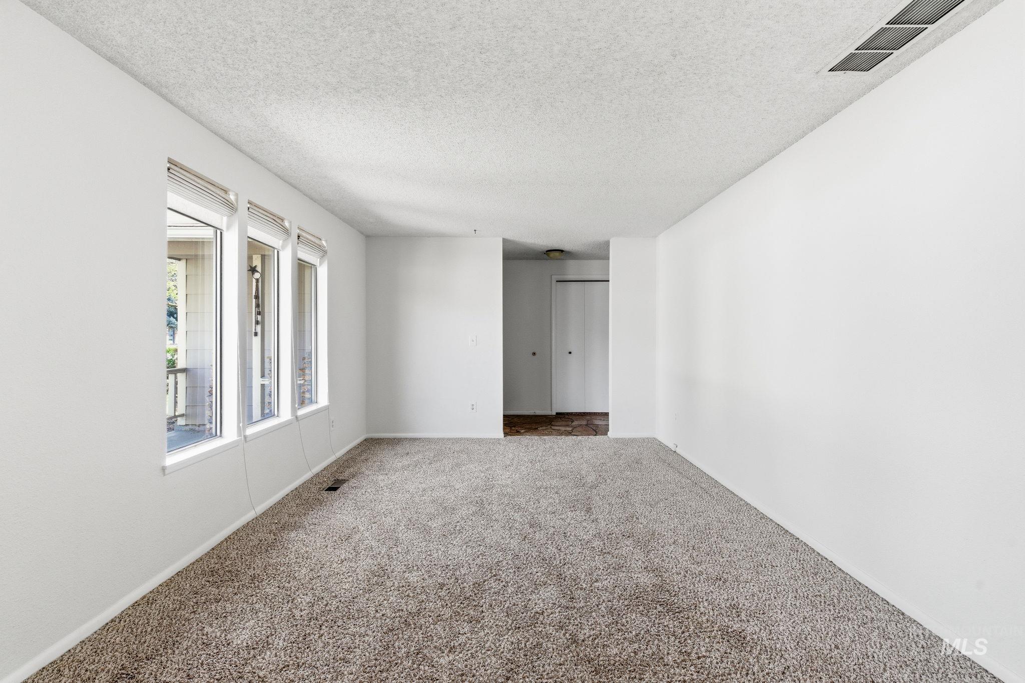 3911 South Constitution Way Boise, ID 83706 - Photo 8 of 40 Carpeted spare room with a textured ceiling and baseboards