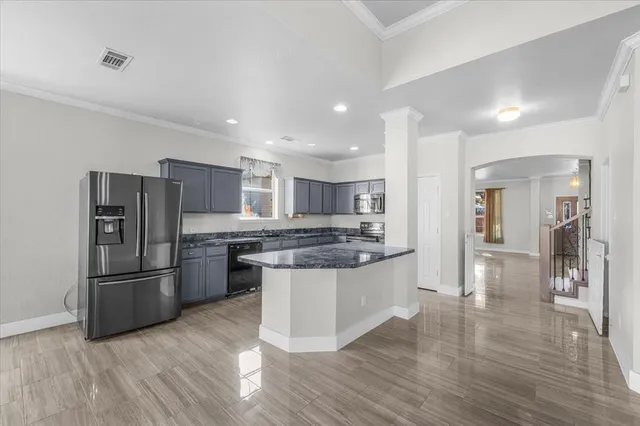 a kitchen with stainless steel appliances granite countertop a refrigerator and a stove top oven