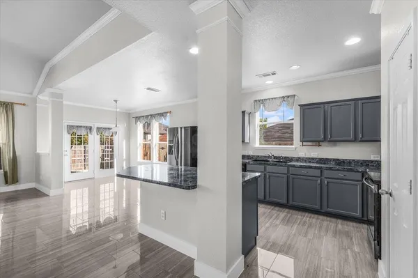 a large kitchen with granite countertop a stove and a sink