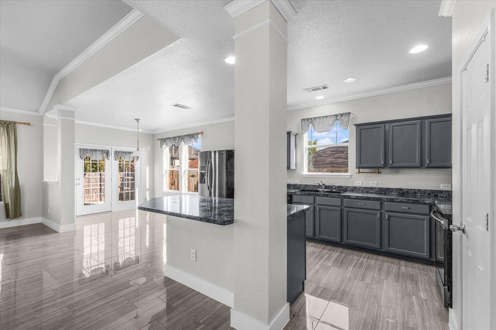 3625 Black Ranch Court Fort Worth, TX 76262 - Photo 14 of 30 a large kitchen with granite countertop a stove and a sink