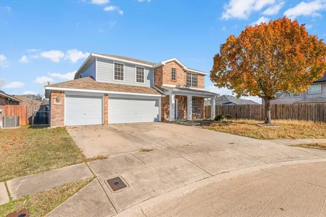 a front view of a house with a yard and a garage