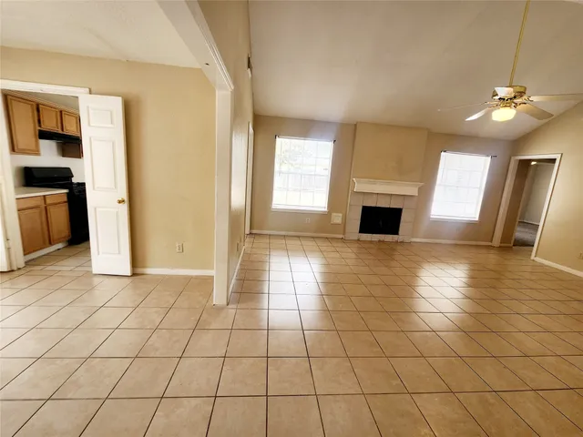 an empty room with windows and fireplace