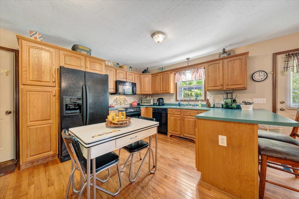 4081 Daugherty Road Salem, VA 24153 - Photo 13 of 34 a kitchen with stainless steel appliances a refrigerator a stove a sink and a dining table with wooden floor