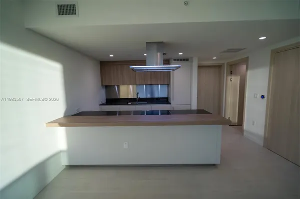 a living room with stainless steel appliances kitchen island a stove a refrigerator and a refrigerator