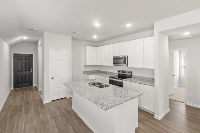 a kitchen with granite countertop stainless steel appliances and wooden cabinets
