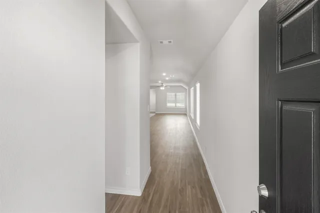 a view of a hallway with wooden floor