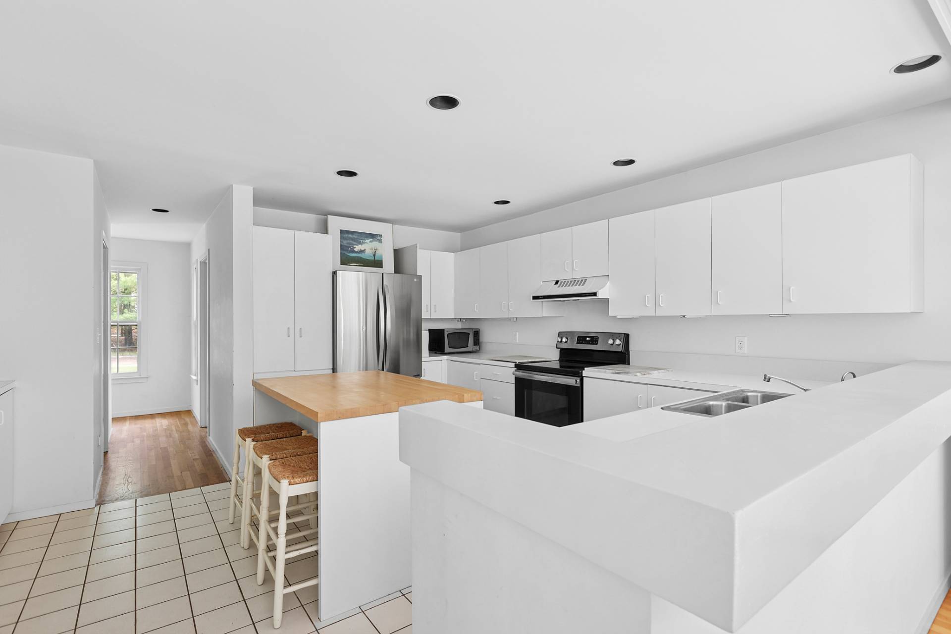 144 Hands Creek Road East Hampton, NY 11937 - Photo 7 of 32 a kitchen with stainless steel appliances kitchen island sink refrigerator and cabinets