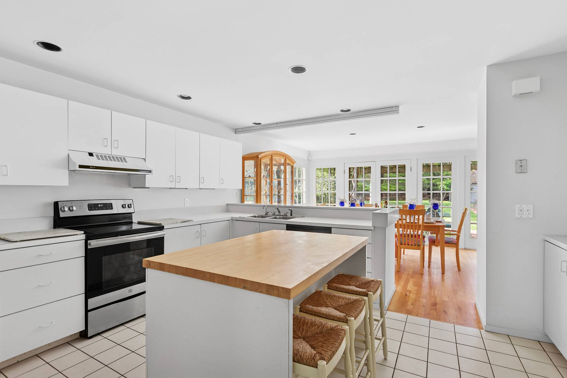 144 Hands Creek Road East Hampton, NY 11937 - Photo 9 of 32 a kitchen with stainless steel appliances granite countertop a stove a refrigerator a stove a dining table and chairs with wooden floor