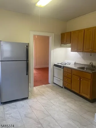 a kitchen with stainless steel appliances granite countertop a refrigerator a stove a sink and a refrigerator