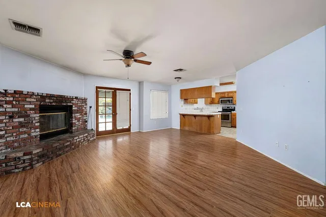 a view of an empty room with a fireplace and a window