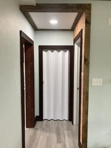 a view of a hallway with wooden floor and closet