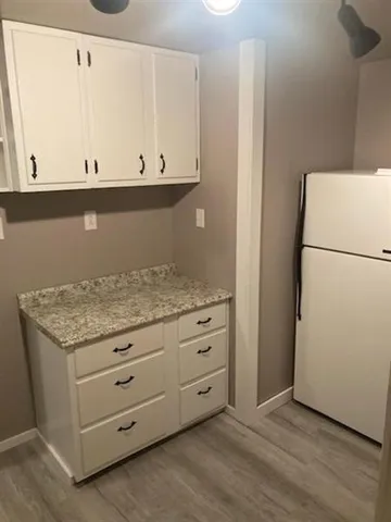a kitchen with granite countertop cabinets and refrigerator