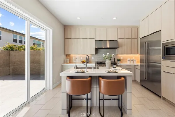 a kitchen with stainless steel appliances a sink a table and chairs