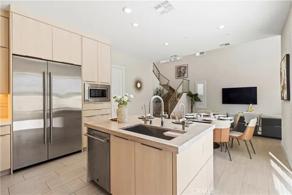 a kitchen with stainless steel appliances kitchen island granite countertop a sink and a refrigerator