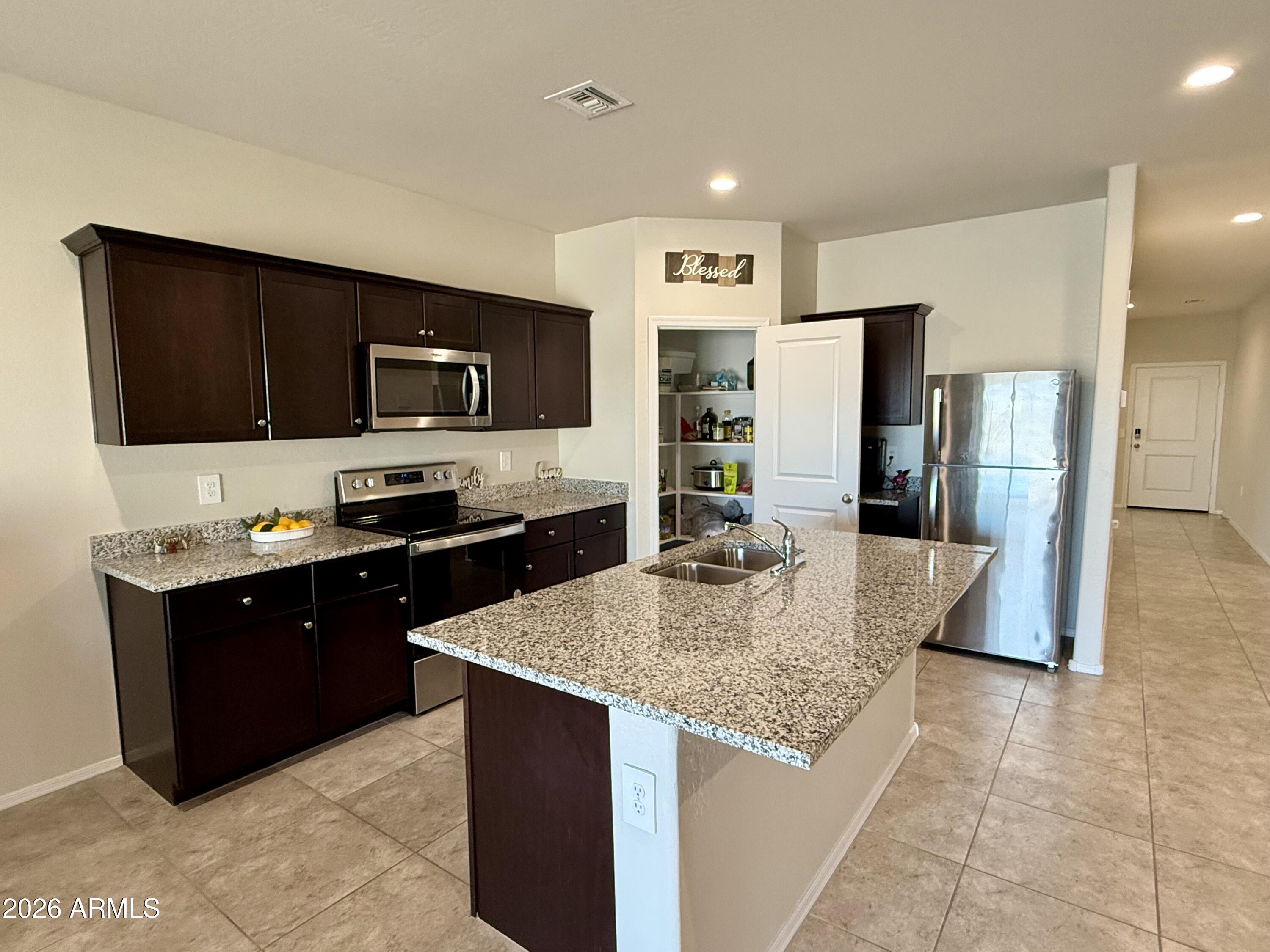 2207 South 46th Street Coolidge, AZ 85128 - Photo 11 of 35 a kitchen with stainless steel appliances granite countertop a refrigerator a stove a sink a microwave and a refrigerator