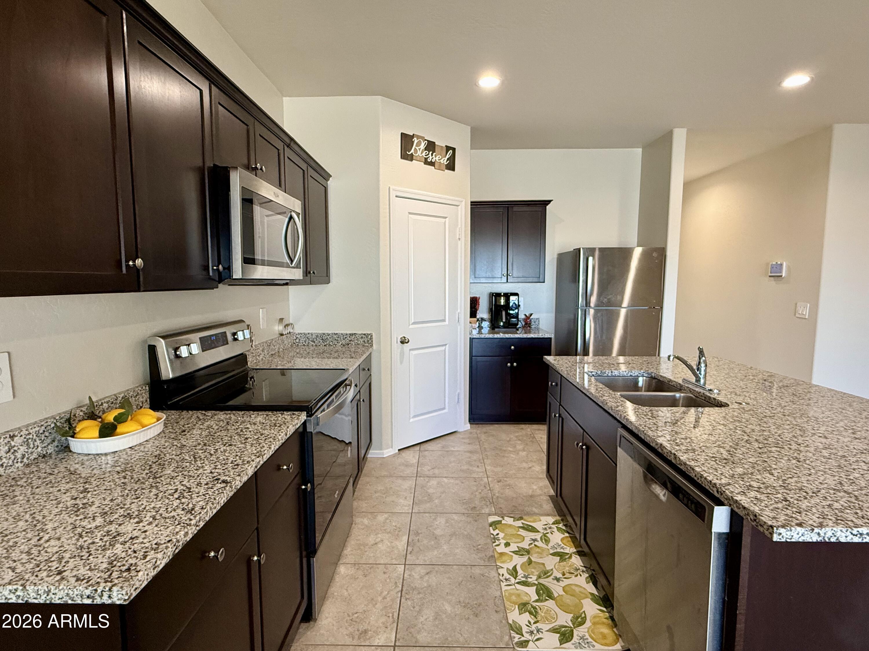 2207 South 46th Street Coolidge, AZ 85128 - Photo 12 of 35 a kitchen with stainless steel appliances granite countertop a sink stove and refrigerator