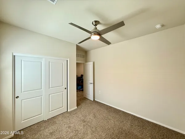 an empty room with closet and fan