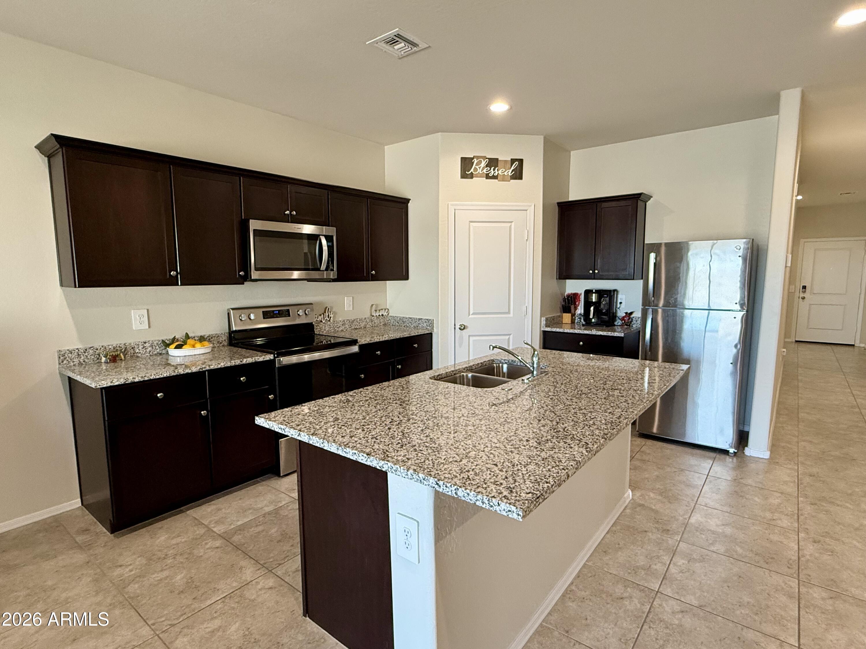 2207 South 46th Street Coolidge, AZ 85128 - Photo 10 of 35 a kitchen with stainless steel appliances granite countertop a refrigerator and a sink