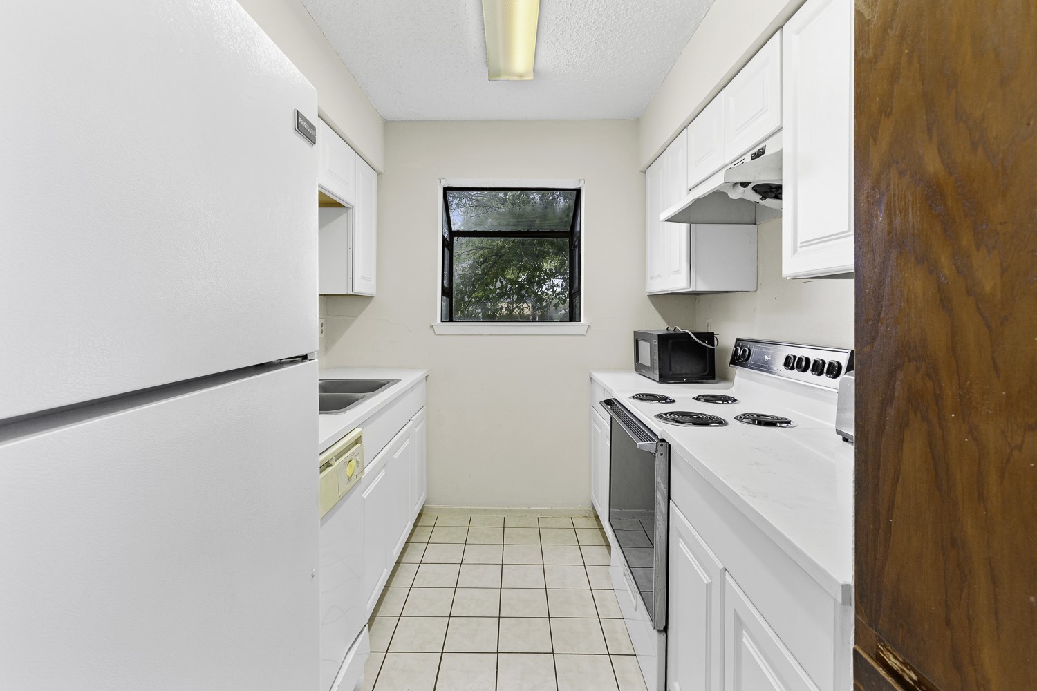 1907 West Loop Austin, TX 78758 - Photo 14 of 31 a kitchen with a stove a sink and a refrigerator