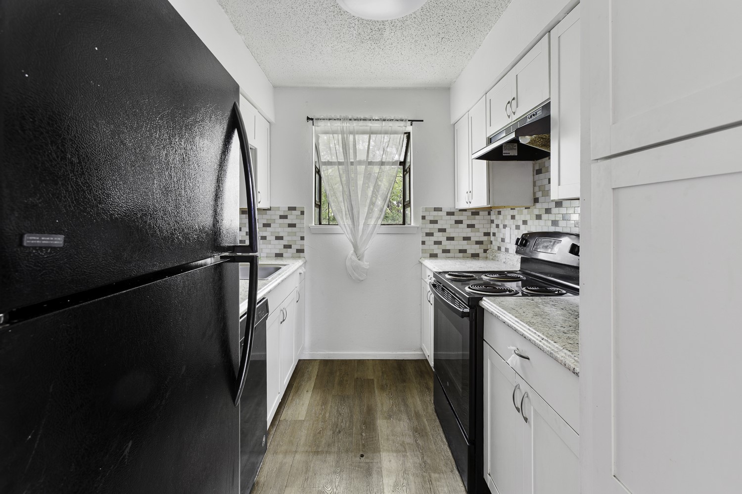 1907 West Loop Austin, TX 78758 - Photo 16 of 22 a kitchen with stainless steel appliances granite countertop a refrigerator a stove a sink and a microwave