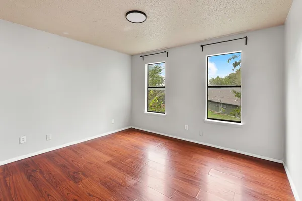 a view of an empty room with wooden floor