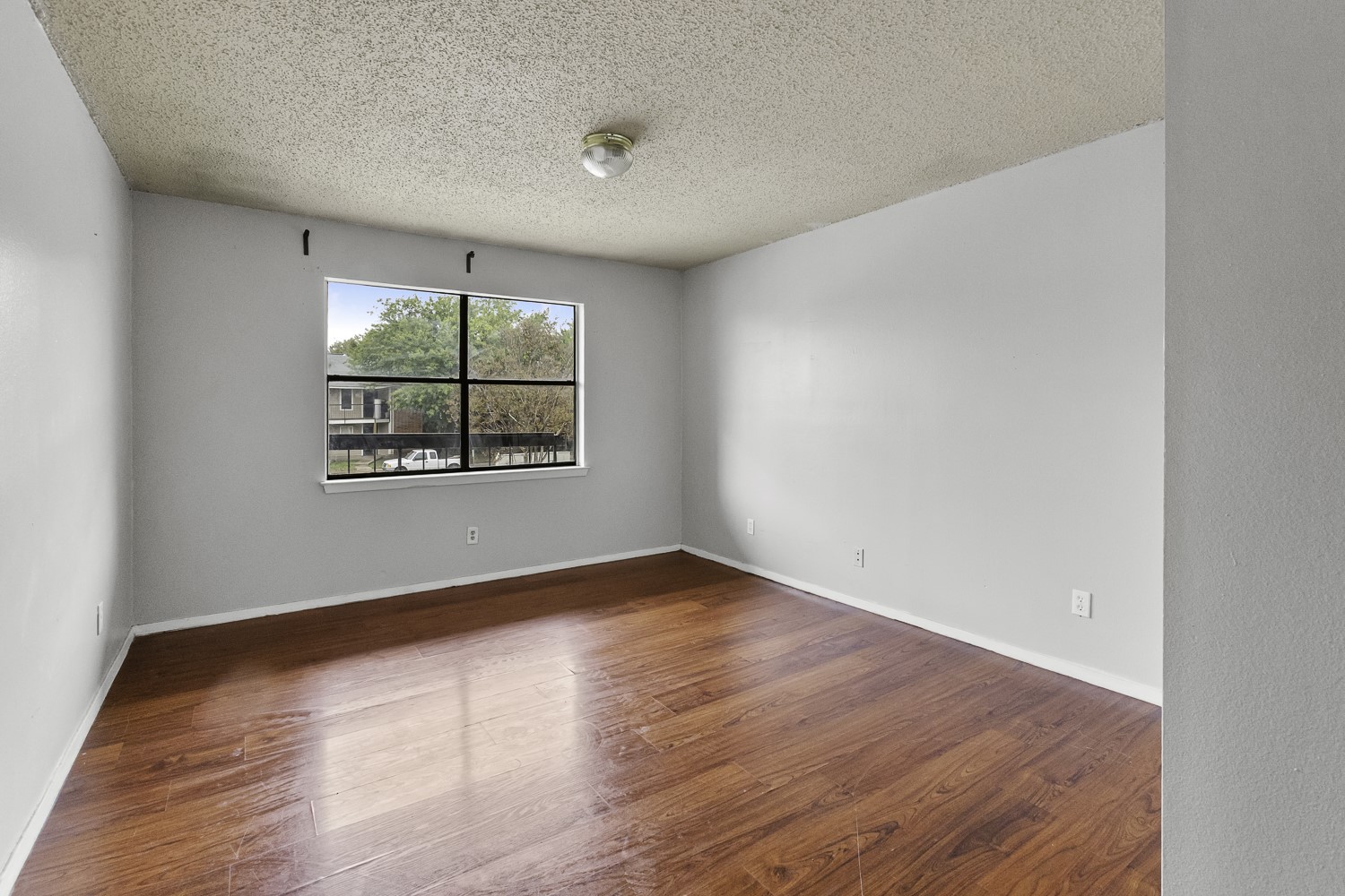 1907 West Loop Austin, TX 78758 - Photo 20 of 22 an empty room with wooden floor and windows