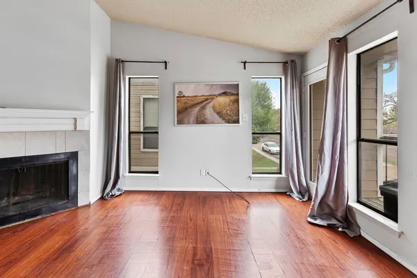 a view of a livingroom with wooden floor and a fireplace