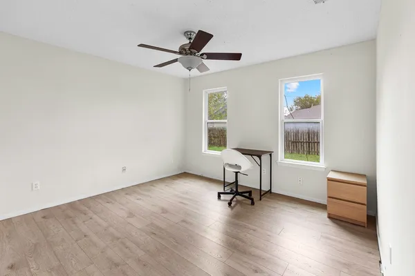 a view of empty room with wooden floor