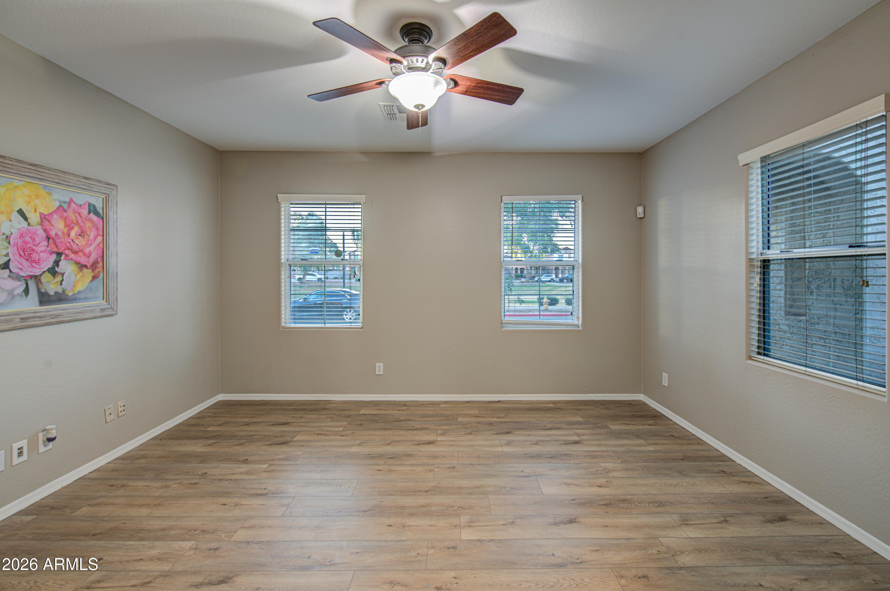 7759 West Monte Vista Road Phoenix, AZ 85035 - Photo 5 of 43 a view of an empty room with window and wooden floor