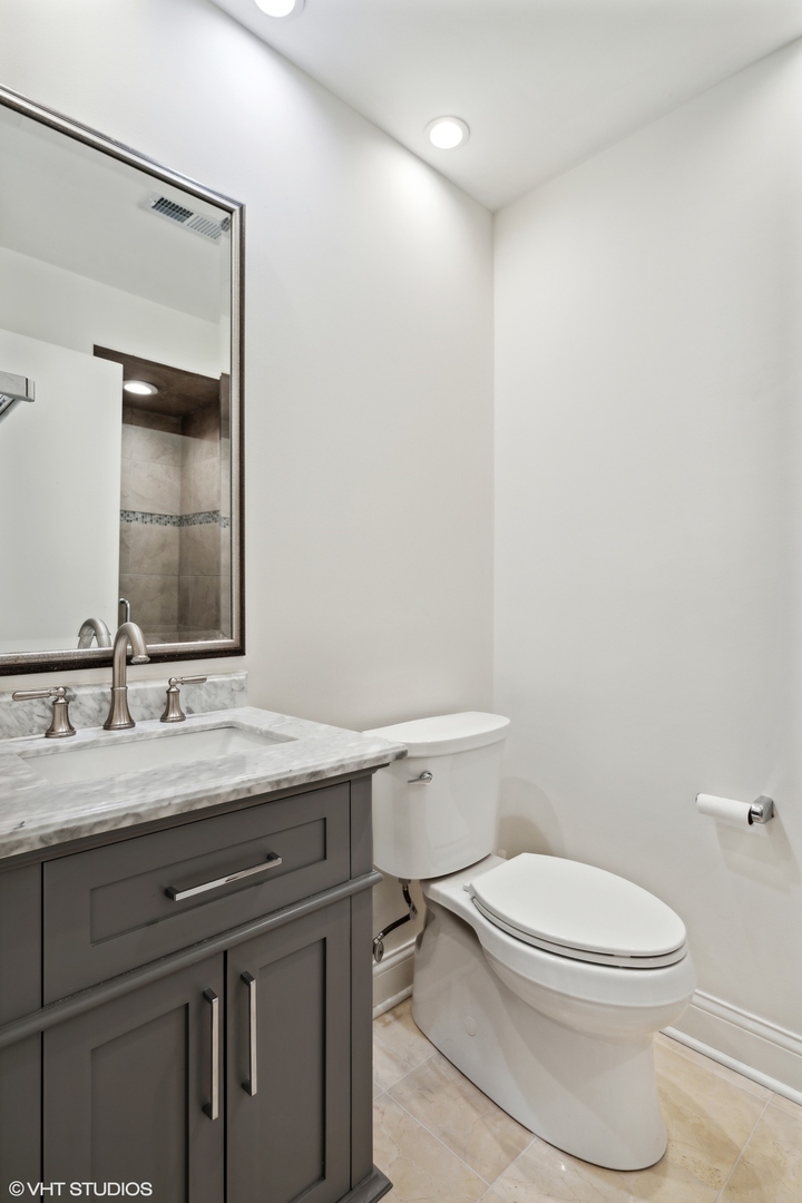 641 West Willow Street, Unit 117 Chicago, IL 60614 - Photo 18 of 44 a bathroom with a granite countertop toilet sink and mirror