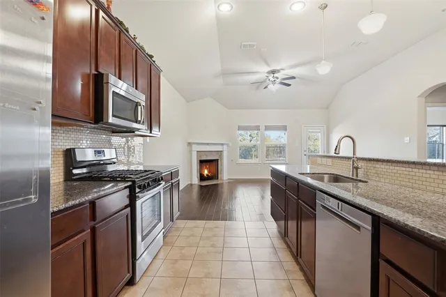 a kitchen with stainless steel appliances granite countertop a sink stove and refrigerator