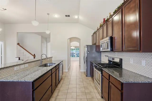 a kitchen with stainless steel appliances granite countertop a sink and stove