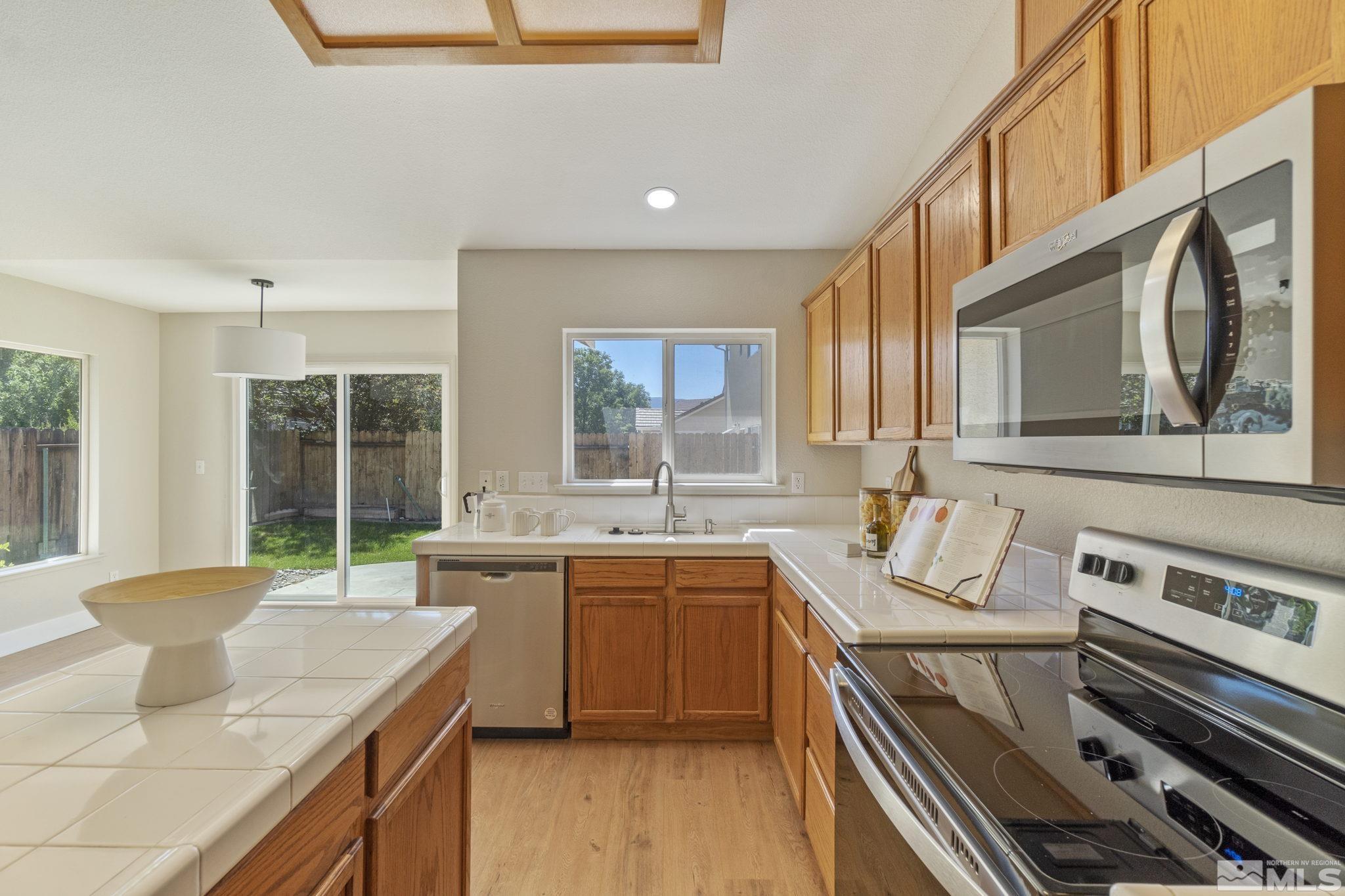9721 Northmont Lane Reno, NV 89521 - Photo 12 of 40 a kitchen with a stove a sink and a refrigerator