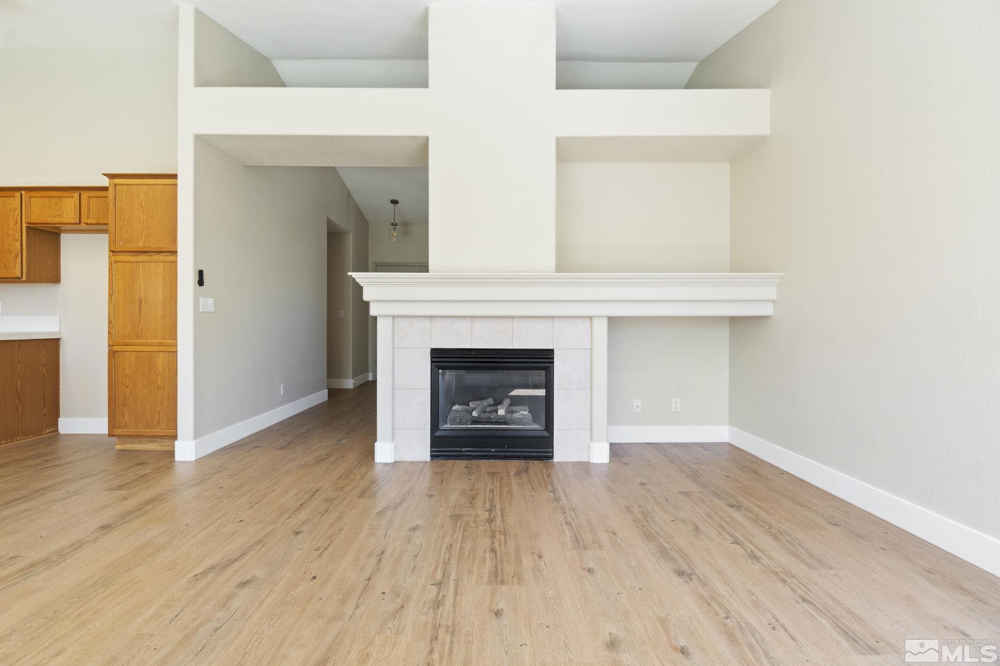 9721 Northmont Lane Reno, NV 89521 - Photo 13 of 40 a view of an empty room with wooden floor and a window