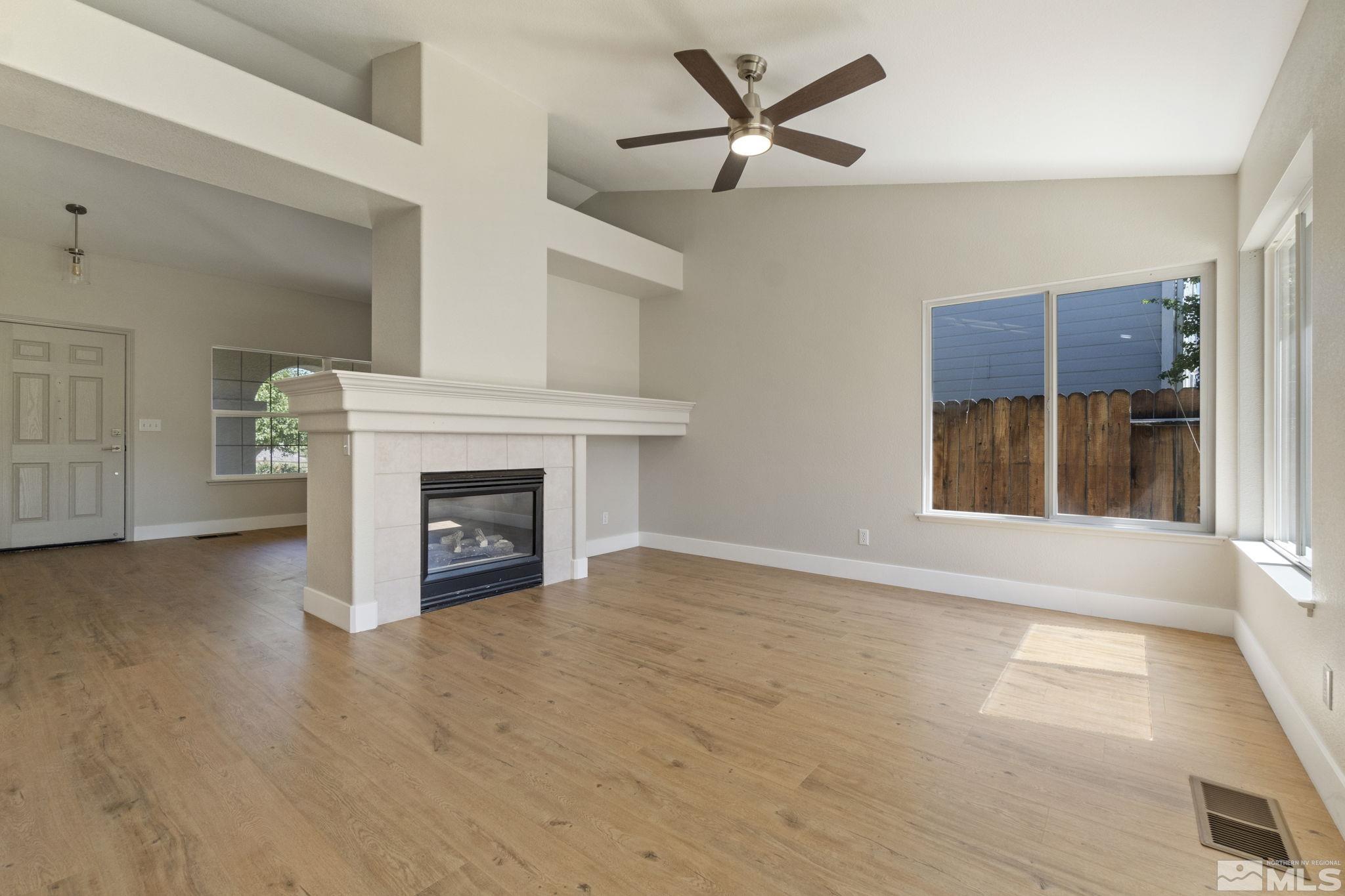 9721 Northmont Lane Reno, NV 89521 - Photo 5 of 40 a view of an empty room with a fireplace and a window