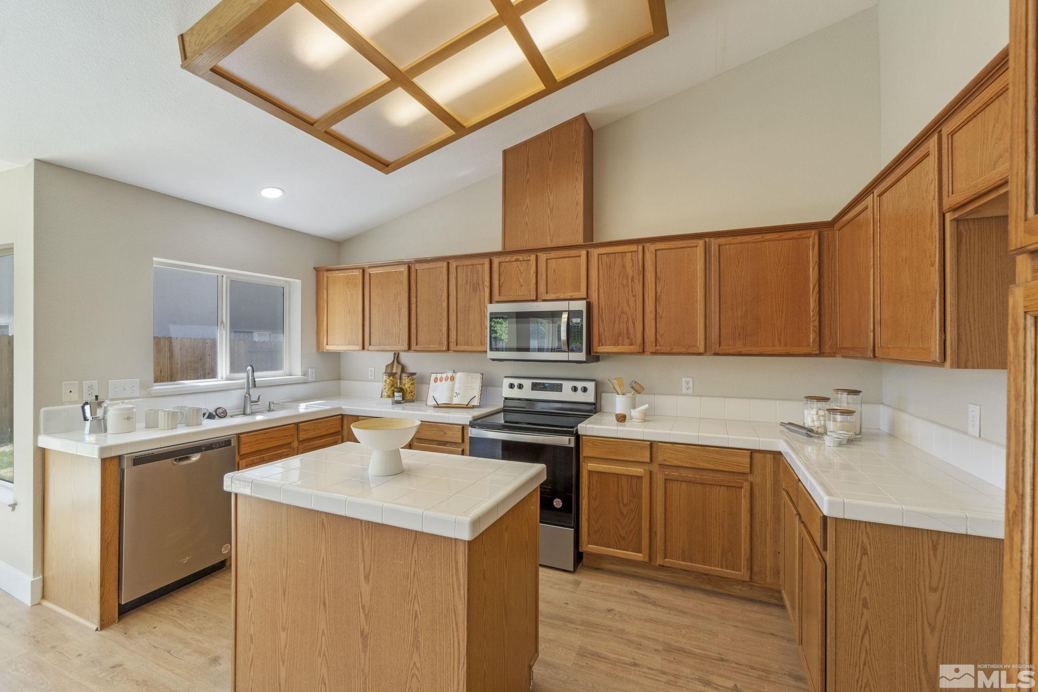 9721 Northmont Lane Reno, NV 89521 - Photo 6 of 40 a kitchen with a sink stove and microwave