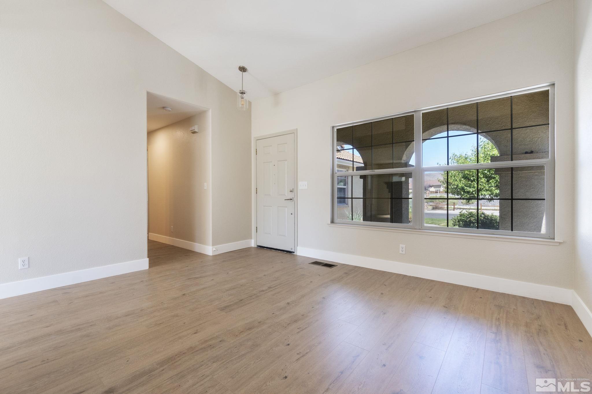 9721 Northmont Lane Reno, NV 89521 - Photo 7 of 40 an empty room with wooden floor and a fireplace