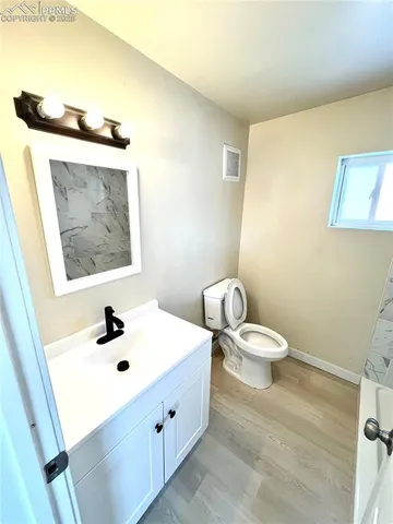 a bathroom with a sink and mirror with toilet