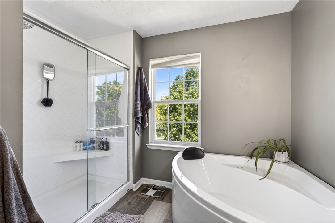 39 Holly Court Springboro, OH 45066 - Photo 18 of 42 This primary bathroom offers a modern walk-in shower and a luxurious soaking tub for relaxation.