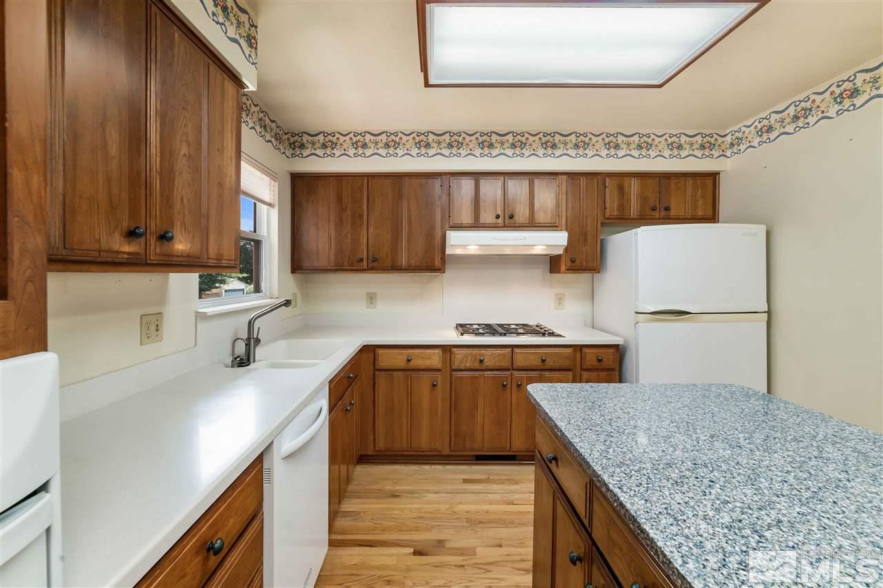 1585 Surf Way Reno, NV 89503 - Photo 3 of 16 a kitchen with stainless steel appliances granite countertop a sink stove and refrigerator