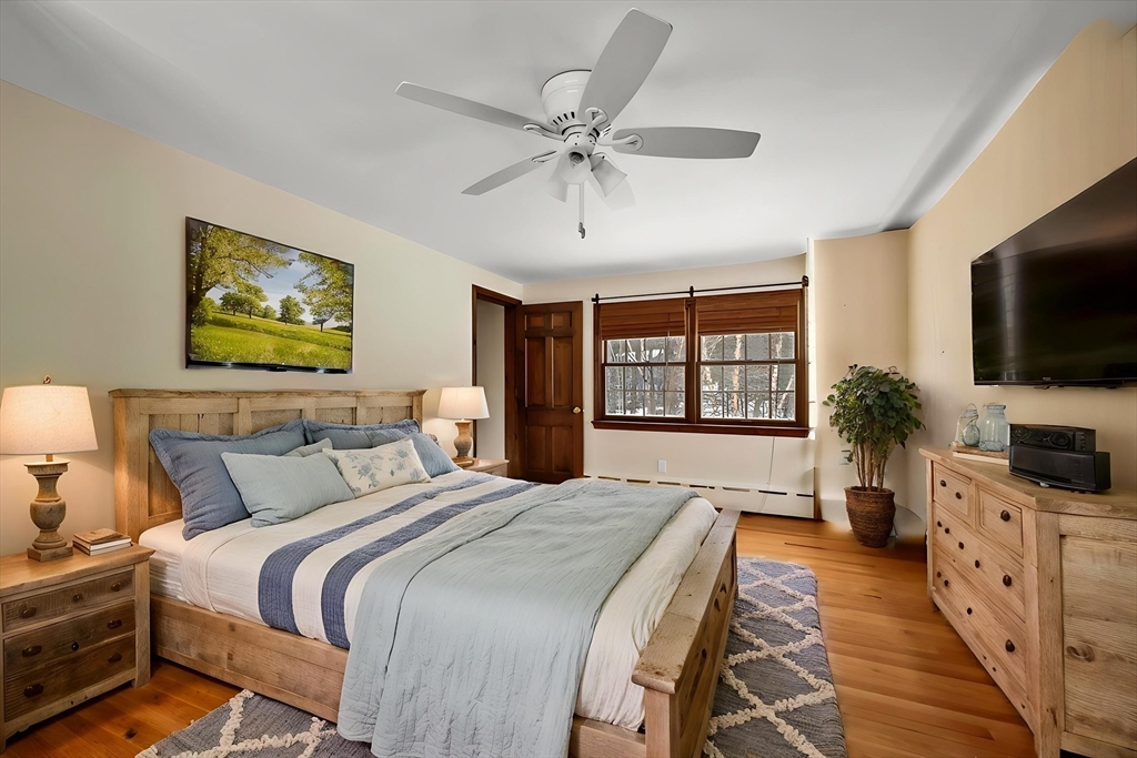 167 Rolling Ridge Road Amherst, MA 01002 - Photo 23 of 39 a spacious bedroom with a large bed and a flat tv screen on dresser