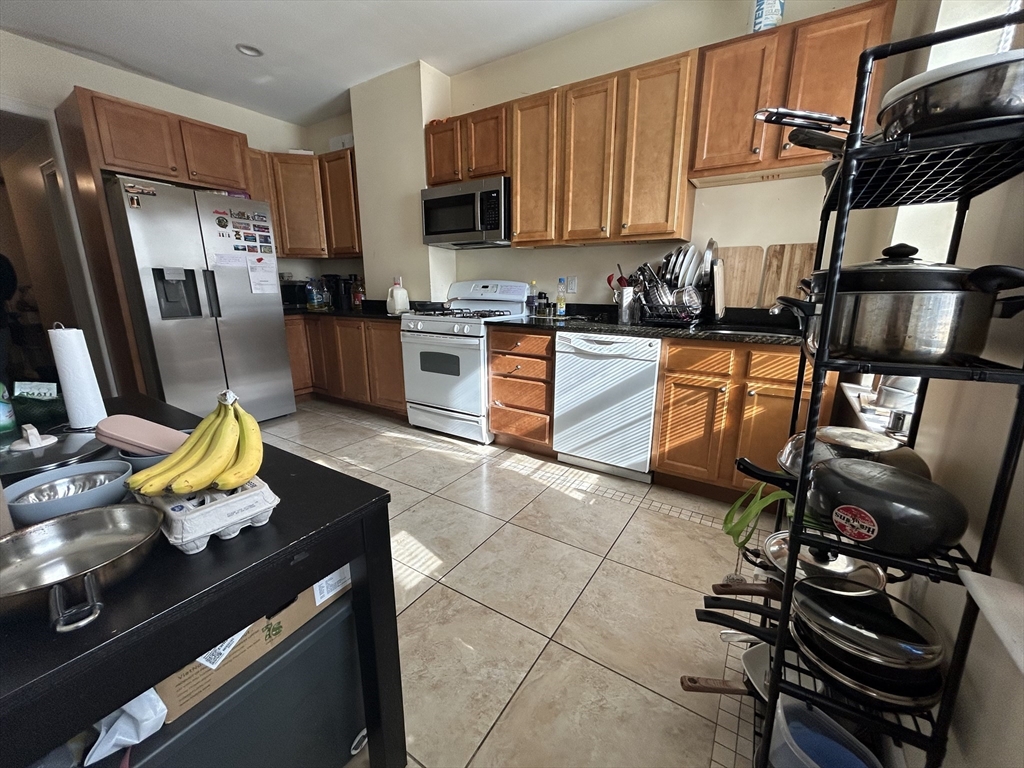 191 Boylston Street, Unit 1 Boston, MA 02130 - Photo 2 of 13 a kitchen with stainless steel appliances wooden cabinets sink and stove